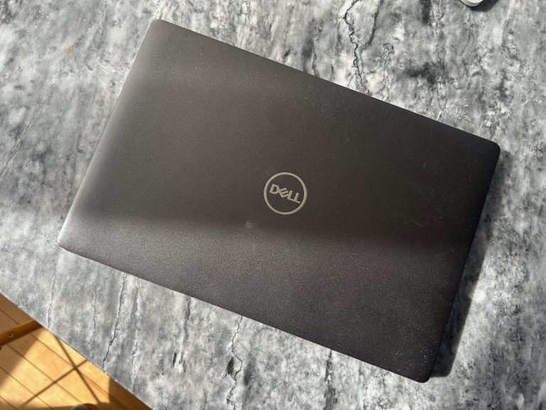 Refurbished Dell laptop on a desk, purchased for a new consulting job to save money and be eco-friendly.